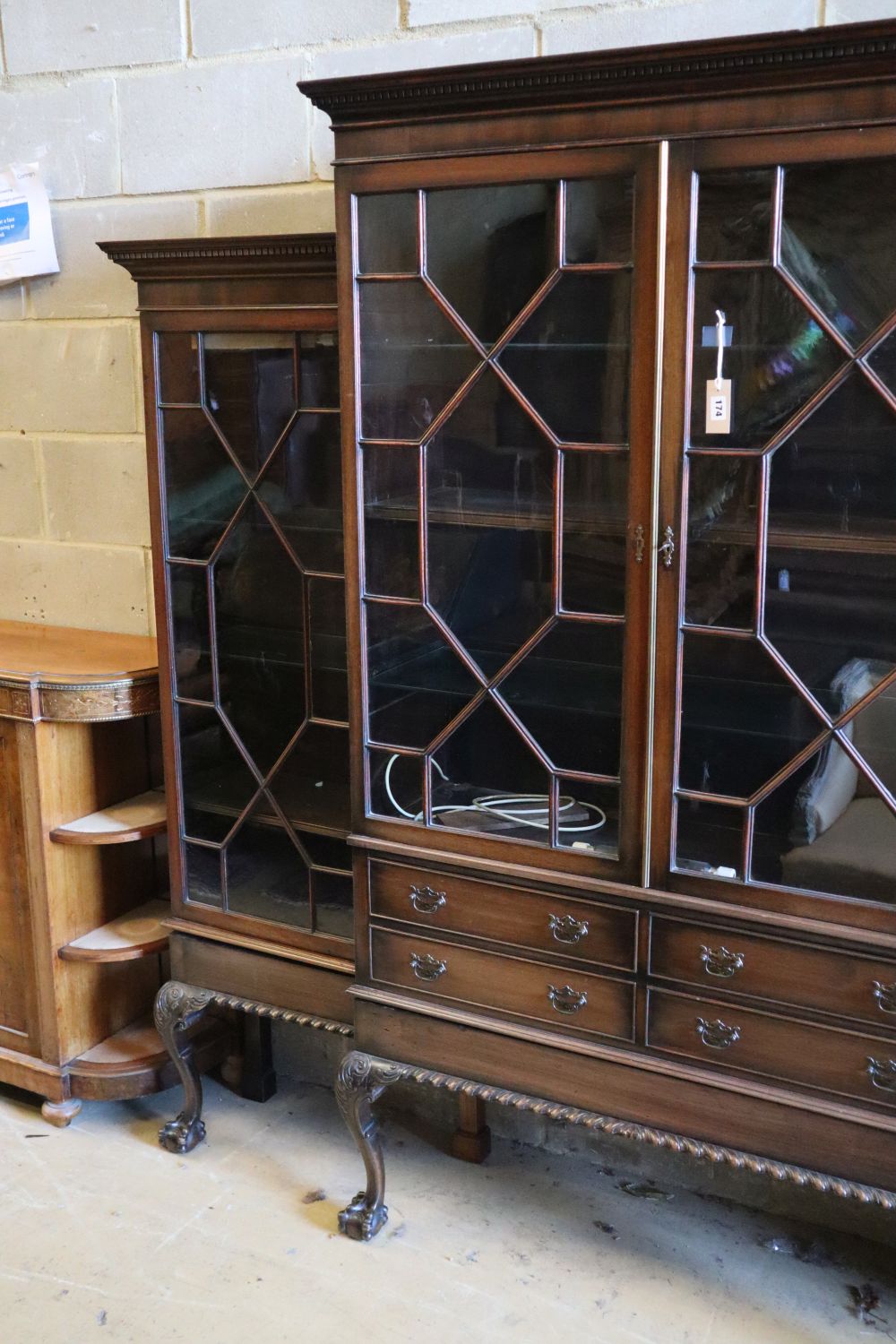 A Chippendale style mahogany breakfront display cabinet fitted four astragal-glazed doors, on cabriole legs with claw and ball feet,
